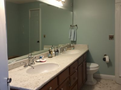 Before: outdated bathroom with old vanity, basic fixtures, and poor lighting