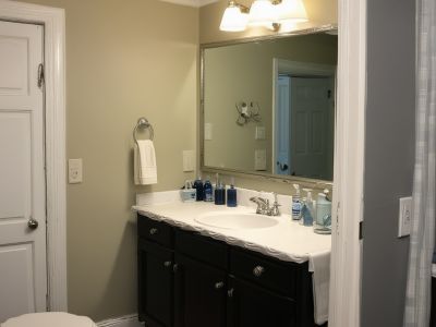 Before renovation: cramped bathroom with basic fixtures, no shower, and dated styling